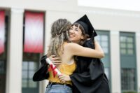 Friends hugging at graduation ceremony