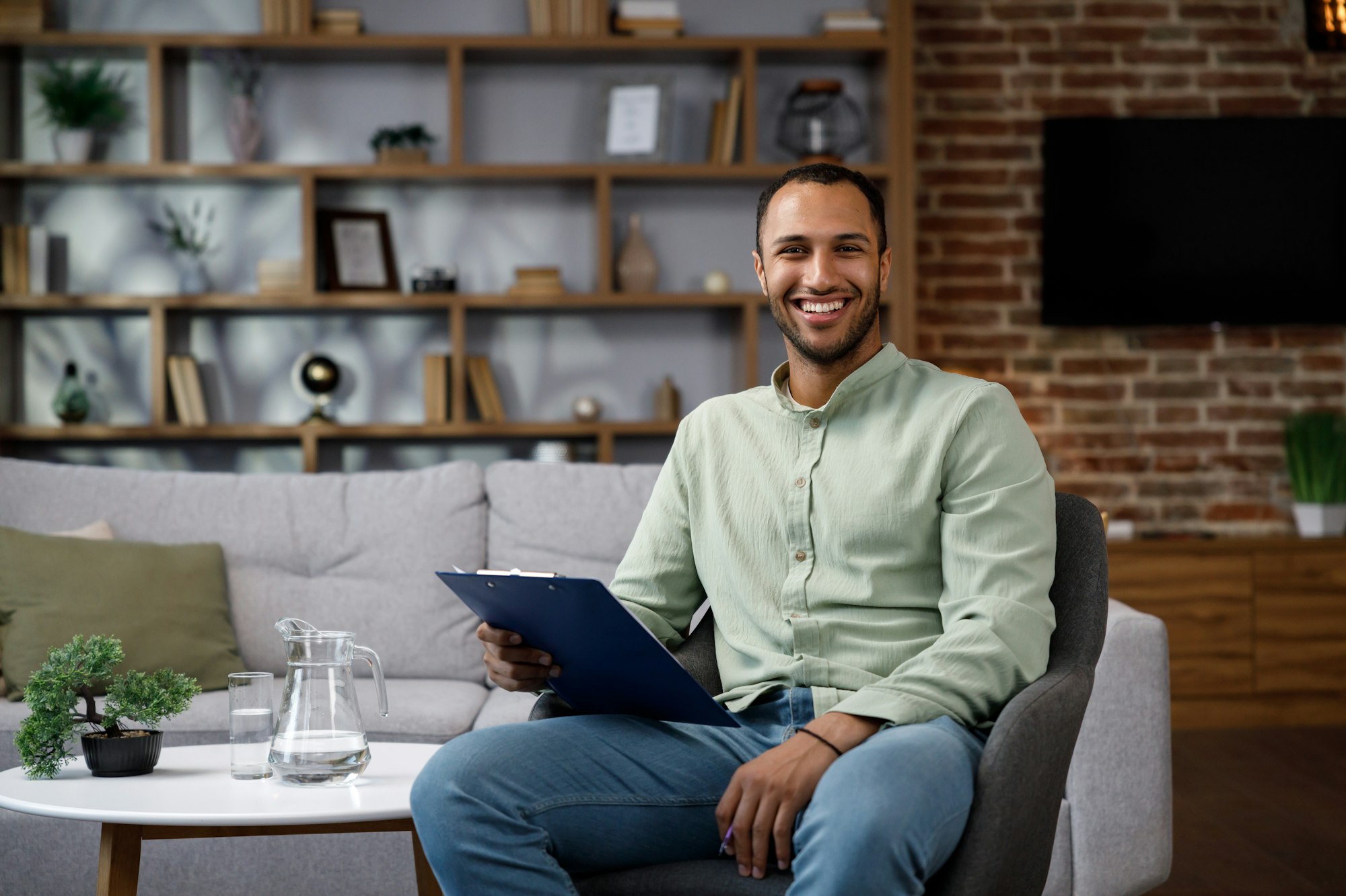 Young African American man sitting at home in a stylish office. Psychologist, coach or businessman