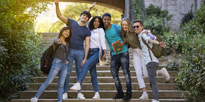 Group of young university multiracial students waving at the camera on some stairs